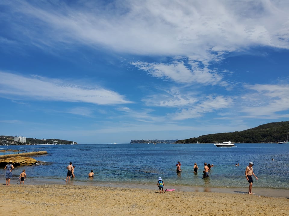 Harbour swimming at Fairlight. Sydney North and South Heads in the distance. Swimmers. Sand. Super yacht.
